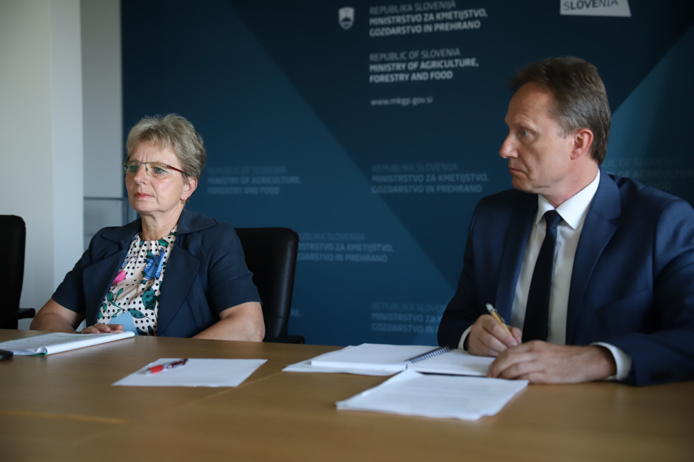 Minister and general director sitting at the table and listening to the conference. 