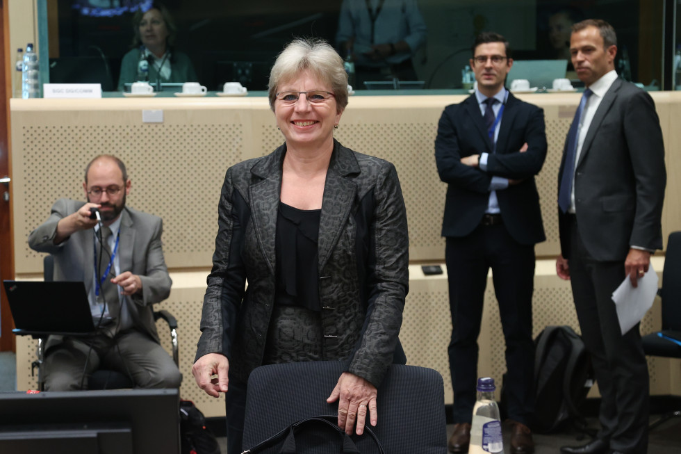 The Minister stands in front of her desk.