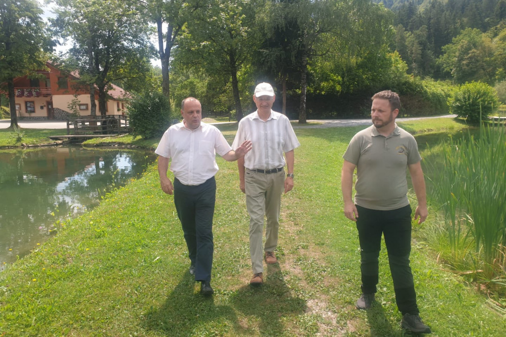 Državni sekretar na travniku z dvema osebama