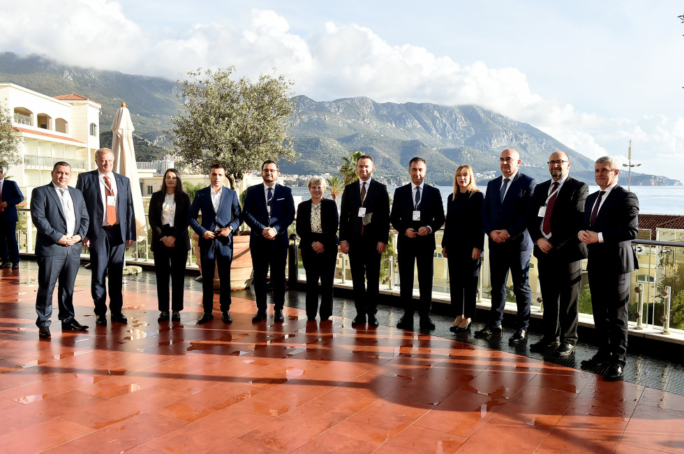 ministri stojijo v polkrogu, v ozadju hribi
