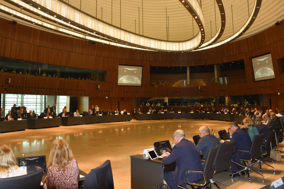 The hall is full of ministers. They are sitting and listening to the meeting. 