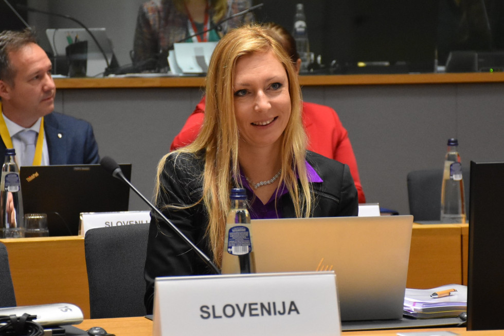 The state secretary is sitting at her table and listening to the meeting. 