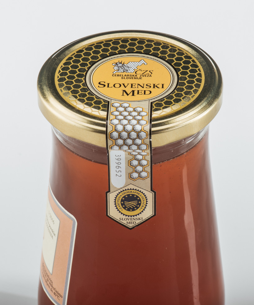 A jar of honey with a lid, featuring an origin label.