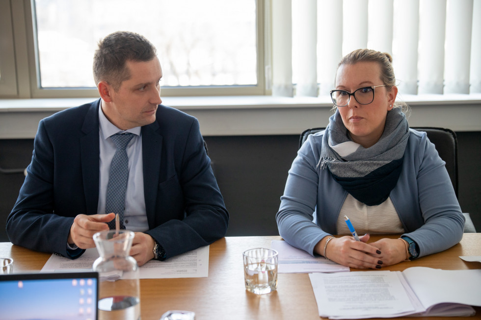 Ministrica in državni sedita za mizo in se pogovarjata.