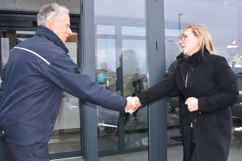 Ministrica Mateja Čalušić se rokuje s predstavnikom civilne zaščite Sandijem Curkom. 