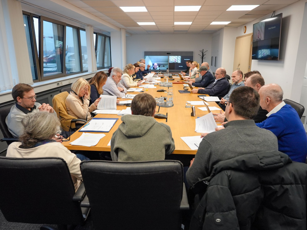 Več oseb sedi za mizo in se pogovarja. 