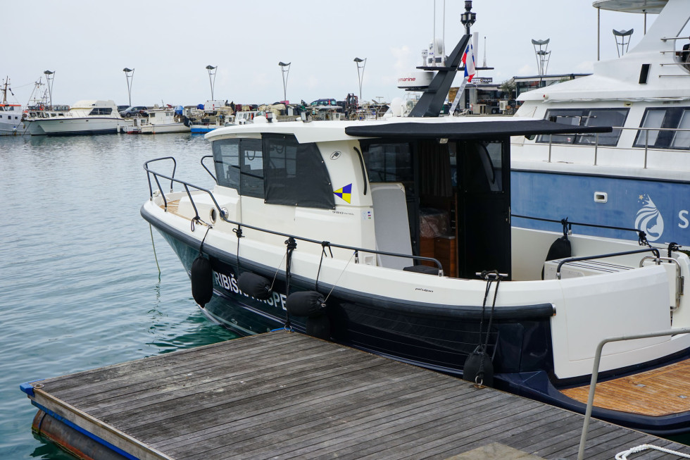 Plovilo, ki je zasidrano ob manjši splav. 