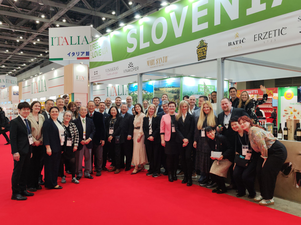 Več oseb stoji in se fotografira. 