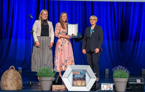 DSC04238 (Three woman are standing and taking a photo. In the middle the award recepient.)