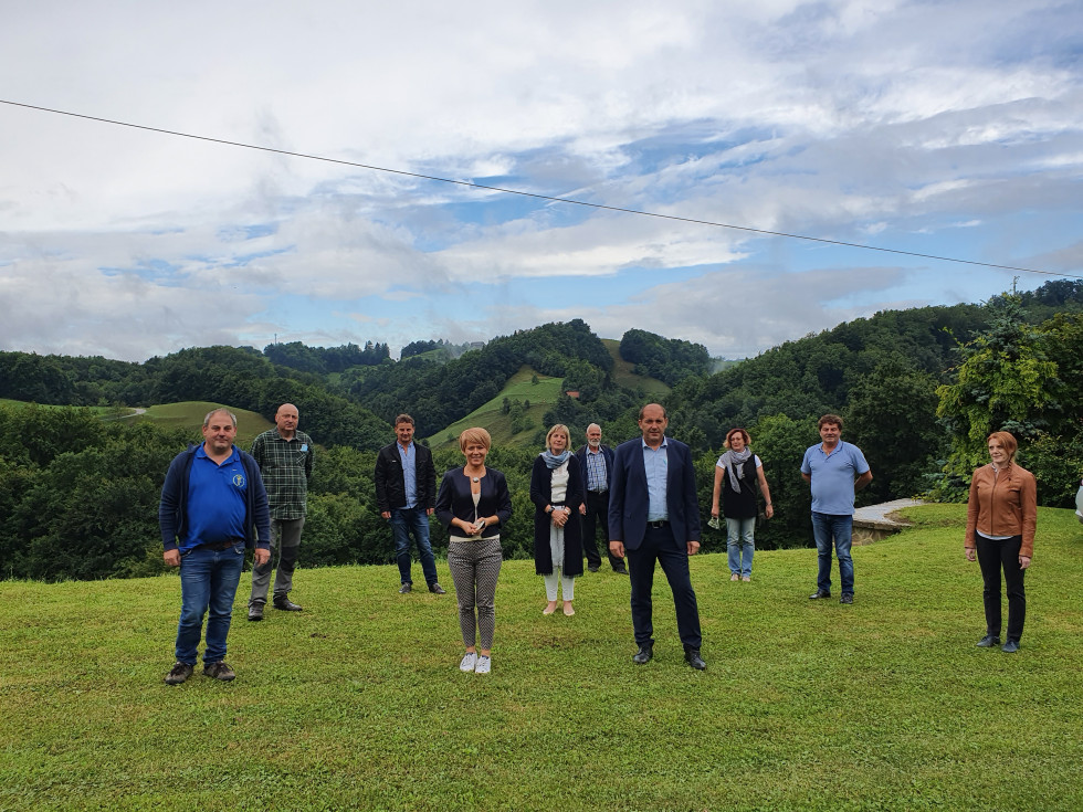 Ministrica in drugi udečleženci na travniku na ogledu kmetije