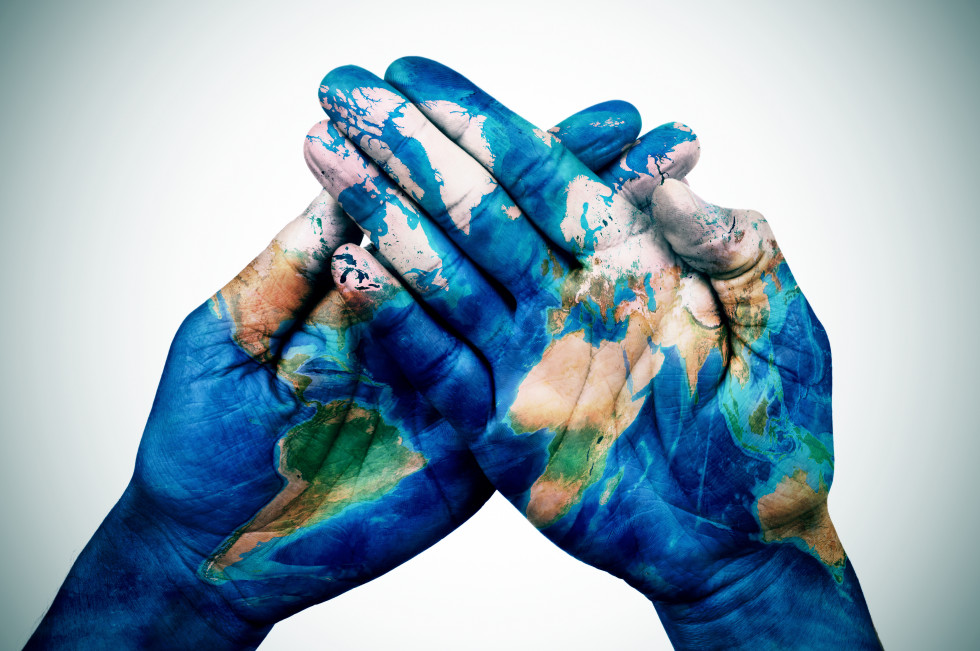 Prekrižane dlani s poslikavo zemljevida sveta