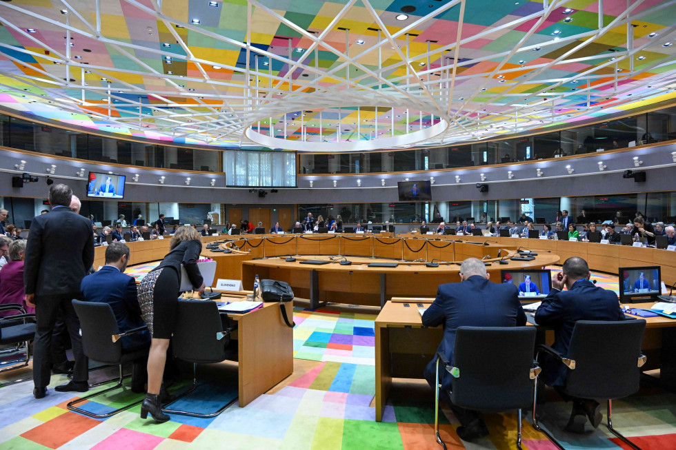 Large hall with a round setup and delegates.