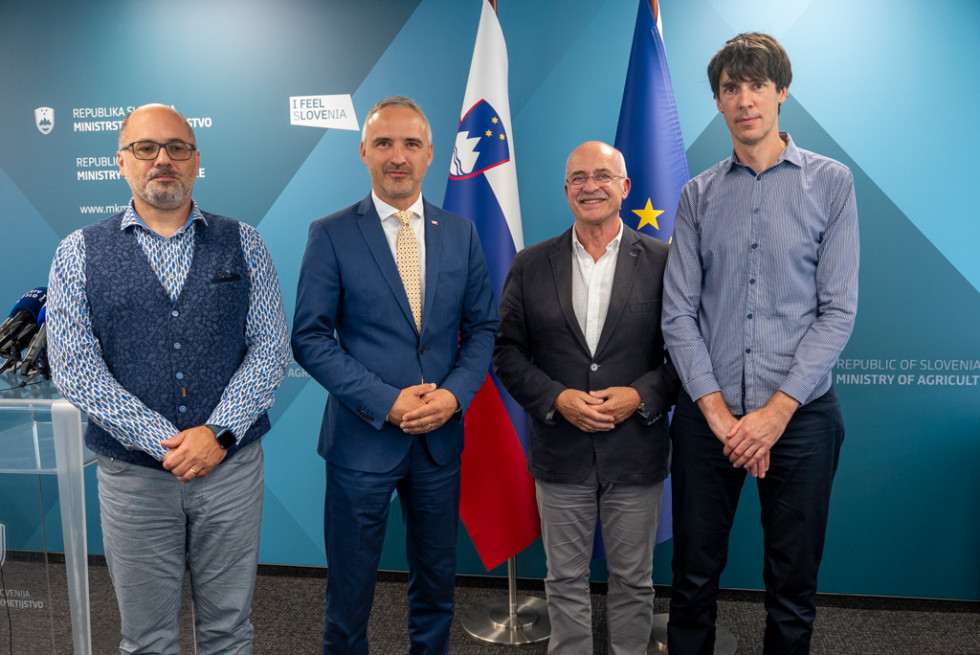 Več oseb stoji in se fotografira. 