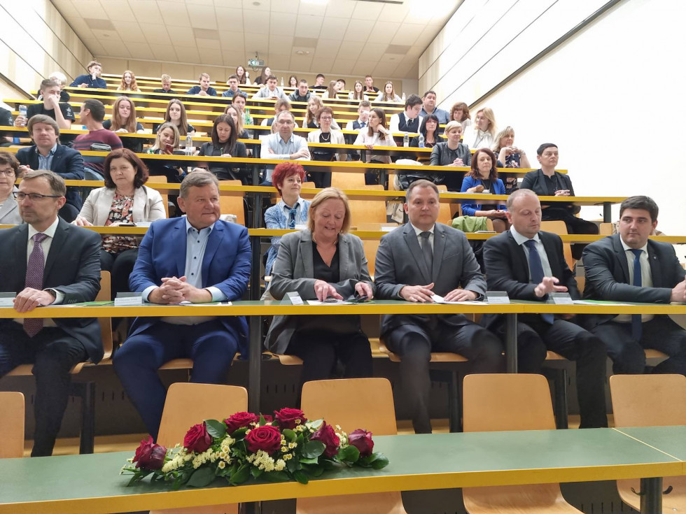 Minister Jevšek in veleposlanica Kraljevine Norveške sedita v prvi klopi predavalnice, okoli njiju sedijo mladi in ostali funkcionarji, ki so bili vabljeni na dogodek.
