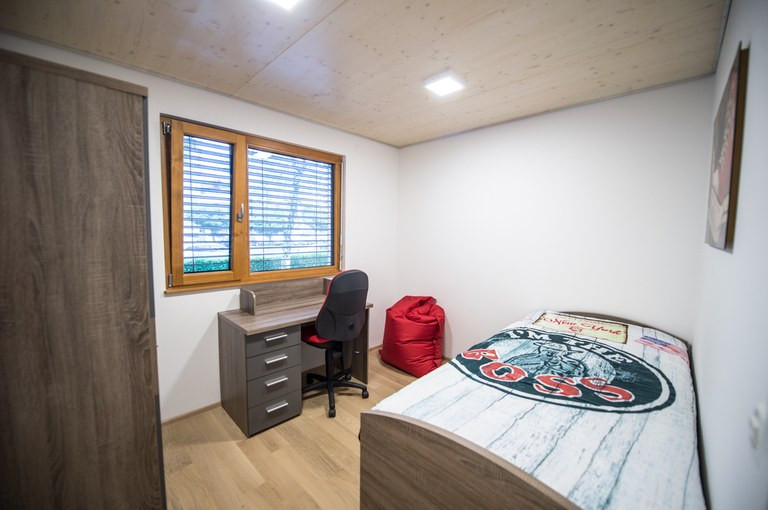 soba s posteljo, pisalno mizo in oknom