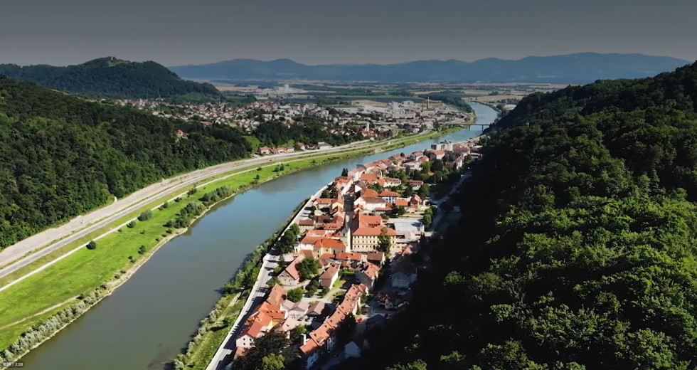 Mesto Krško s ptičje perspektive. Na desni stavbe, na levi reka.