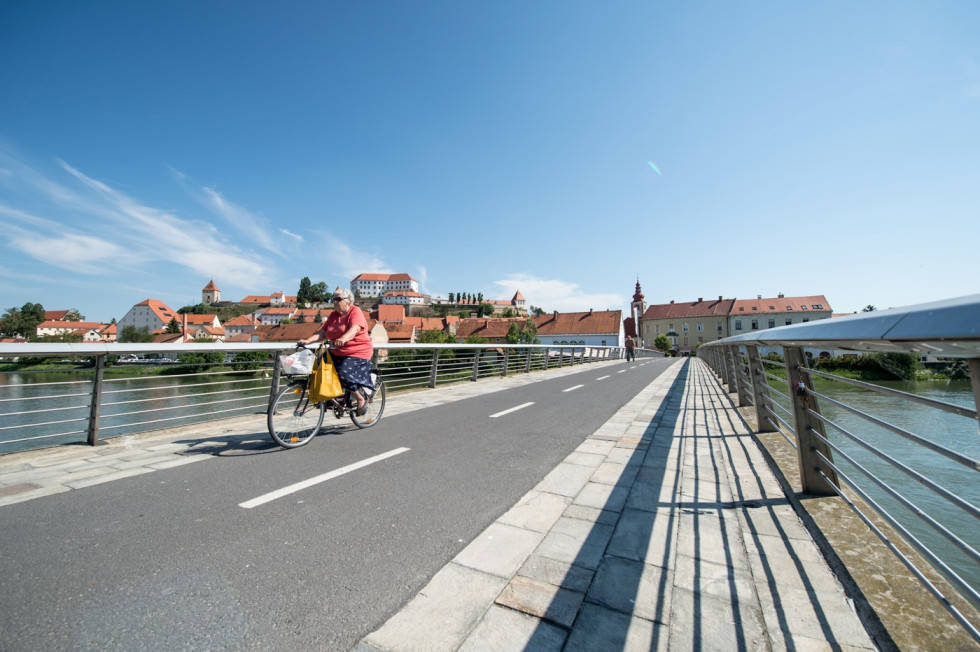 A cyclist riding across a bridge.
