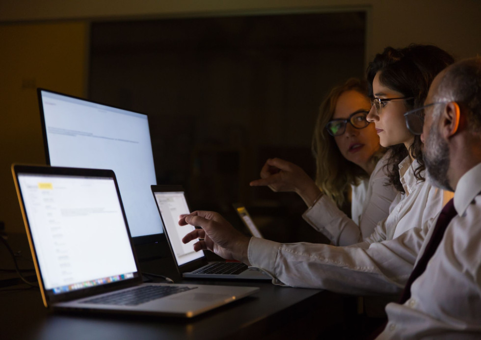 A symbolic photo of researchers looking at computer, laptop and phone screens.