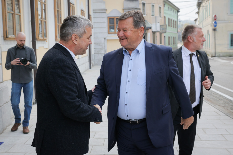 Minister Jevšek se rokuje z moškim.