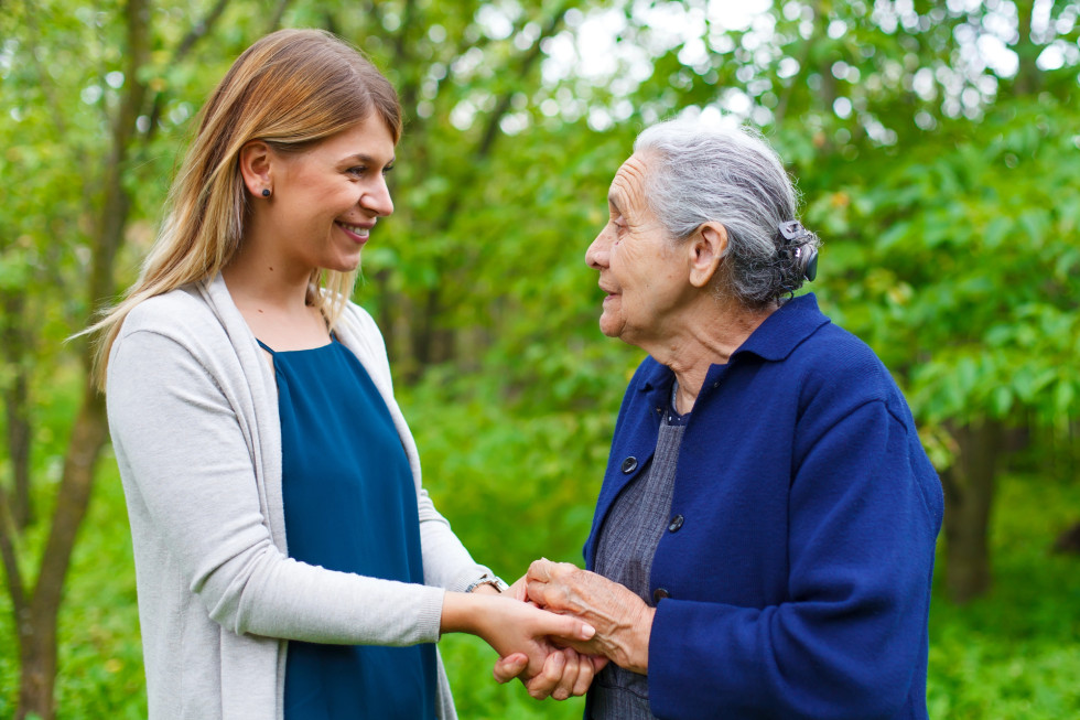 An elderly woman with a younger woman who is a caregiver.