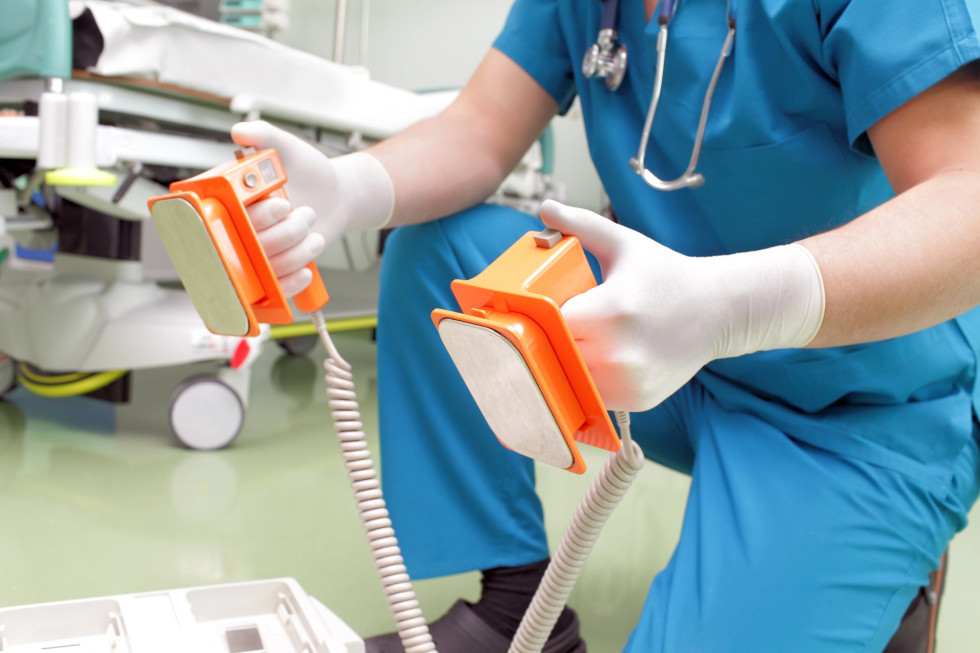 Oseba drži elektrode defibrilator.