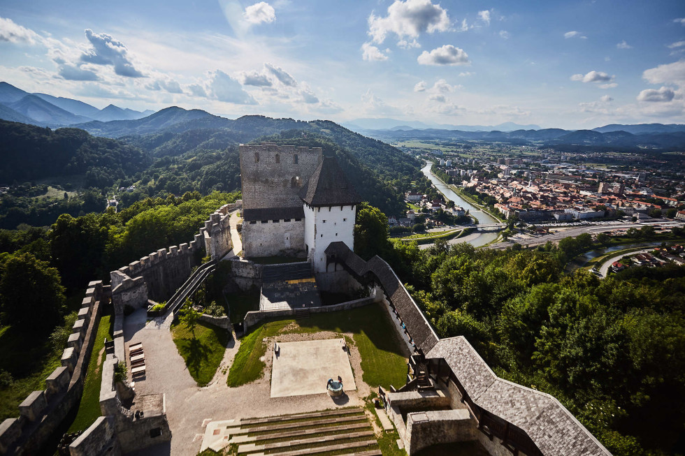 Posnetek iz zraka, v ospredju Stari grad v Celju, v ozadju mesto Celje z okolico.