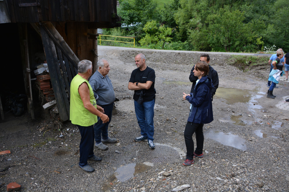 Pred poplavljenim objektom v Črni, v sredini minister Uroš Brežan, desno direktorica Neža Kodre