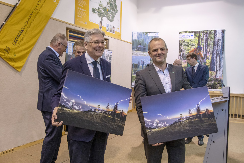 Levo deželni glavar dr. Peter Kaiser, desno minister Uroš Brežan s slikama parka v rokah 
