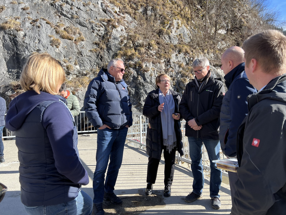 minister in župani stojijo na mostu med pogovorom