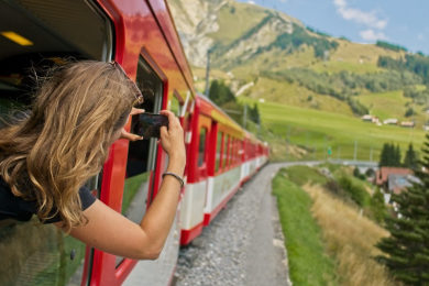 mlado dekle se vozi z vlakom in fotografira alpsko pokrajino