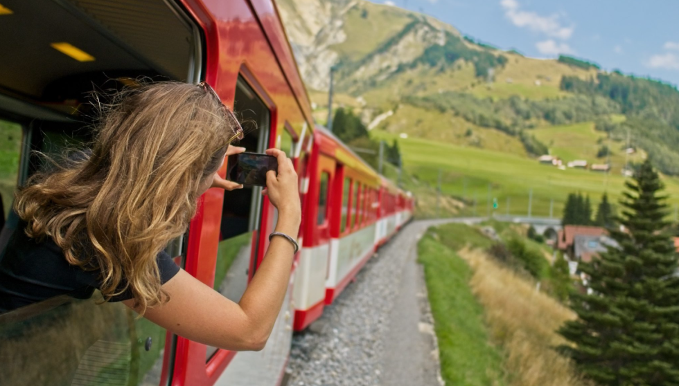 mlado dekle se vozi z vlakom in fotografira alpsko pokrajino