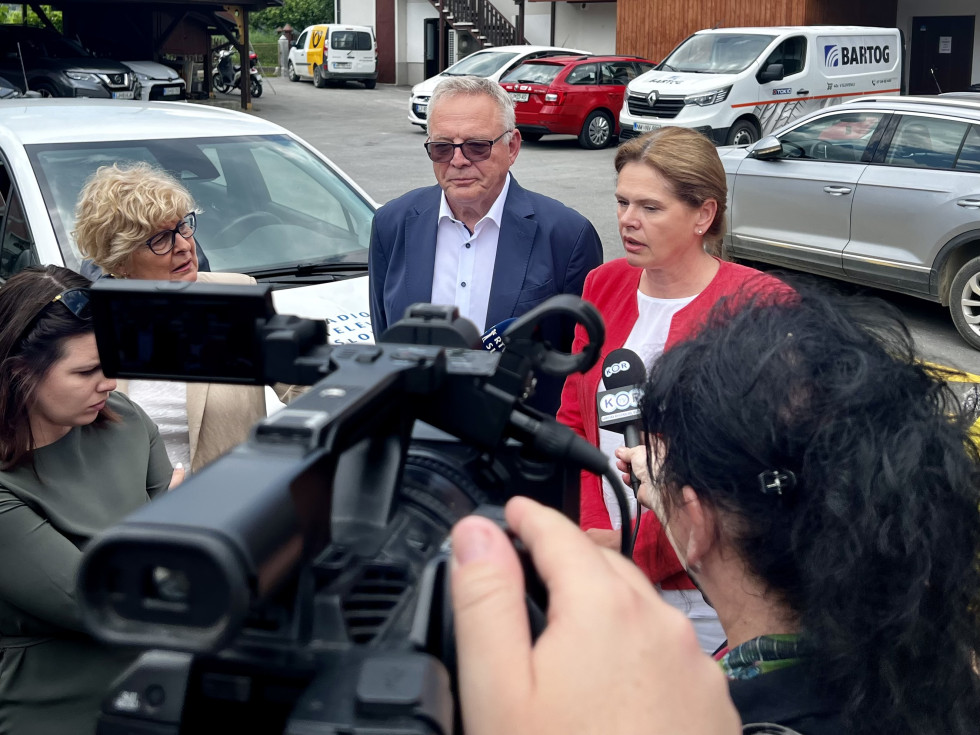 ministra stojita pred kamerami in mikrofoni novinarjev