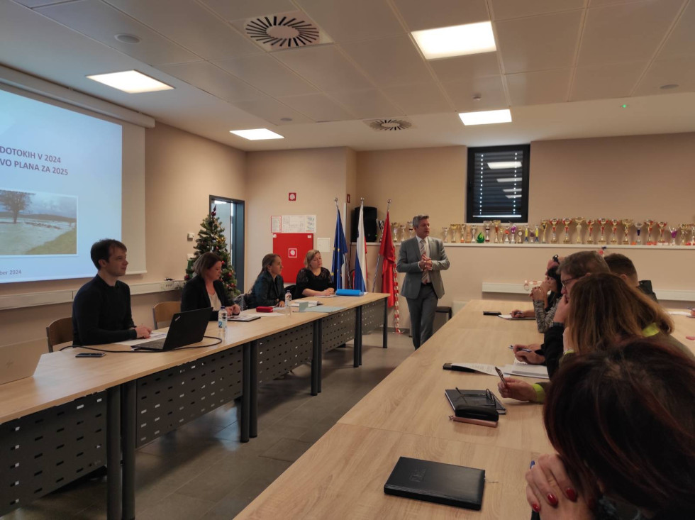 udeleženci srečanja sedijo v sejni sobi, na sredi stoji župan občine Postojna