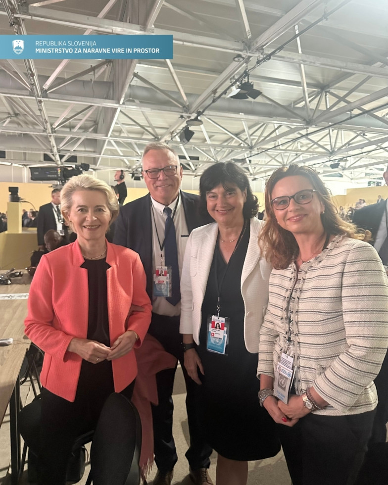 Ursula von der Leyen, minister in dve ženski stojijo nasmejani eden zraven drugega.