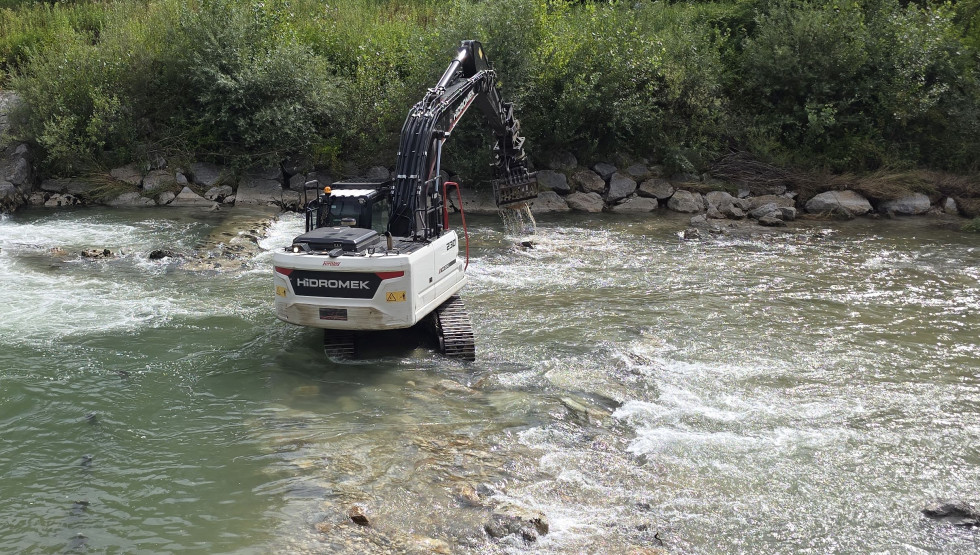 Bager v vodotoku opravlja sanacijska dela.