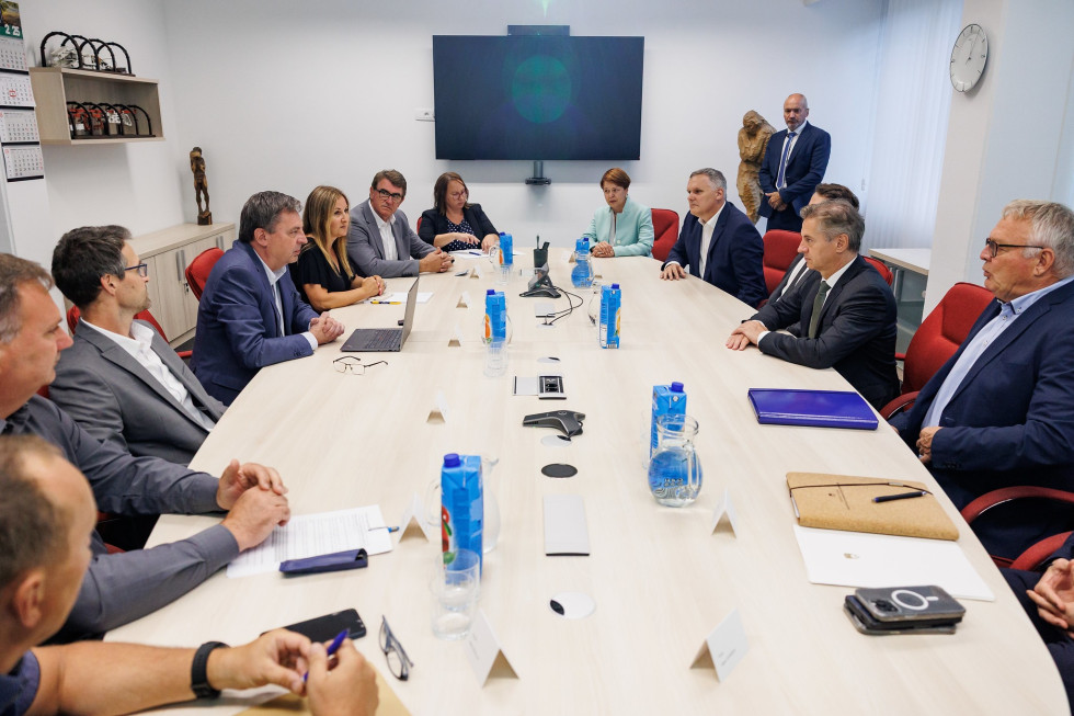 V sejni sobi za mizo sedijo predsednik vlade z ministroma in sodelavci, na drugi strani predstavniki premogovnika