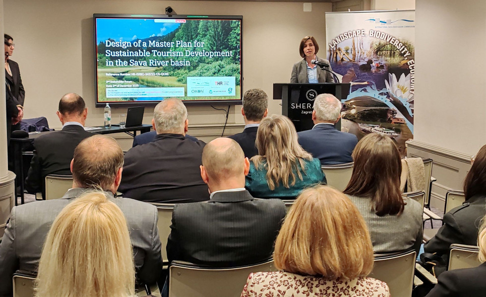 Ljudje sedijo v dvorani na zasedanju foruma.