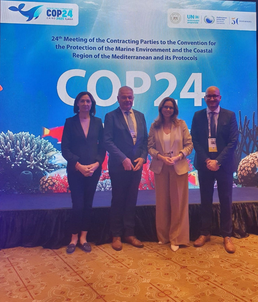 Skupina ljudi stoji na odru in se fotografira