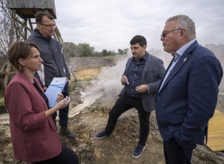Minister Novak s sodelavci pred raziskovalno vrtino, v ozadju zemlja in nekaj izlite tekočine