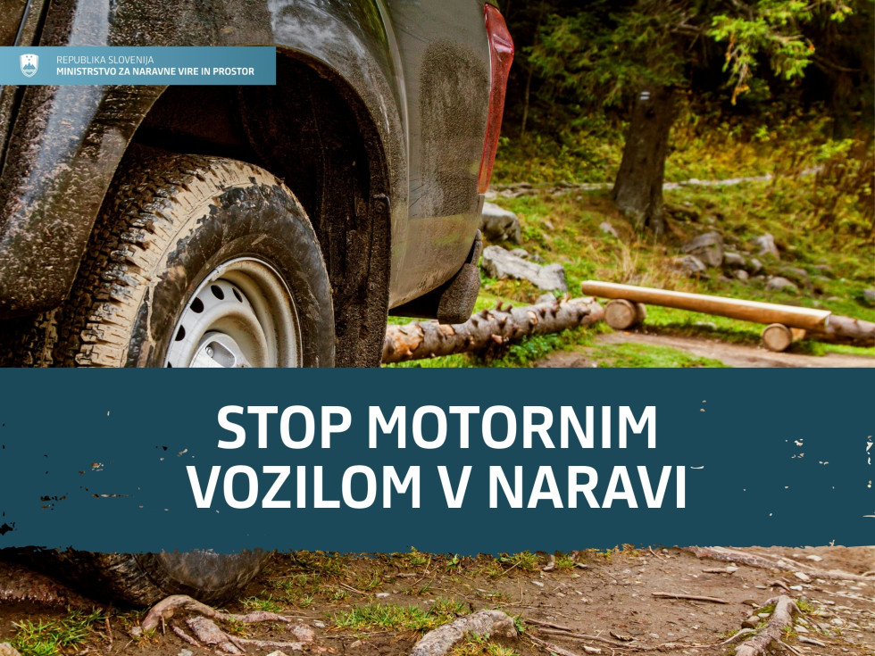 Zadnji del vozila je ustavljen na gozdni poti, v ozadju klopca za počitek