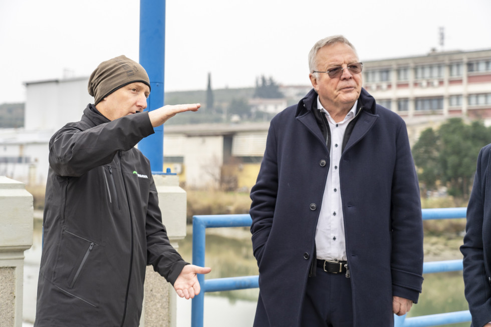 Minister Novak na mostu, kjer mu zaposleni predstavlja delo na vodotoku