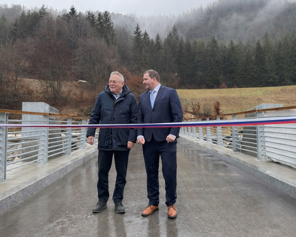Minister se na novem mostu pripravlja, da prereže otvoritveni trak 