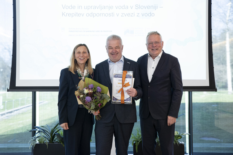 Nagrajenec in podeljevalca nagrade stojijo na odru