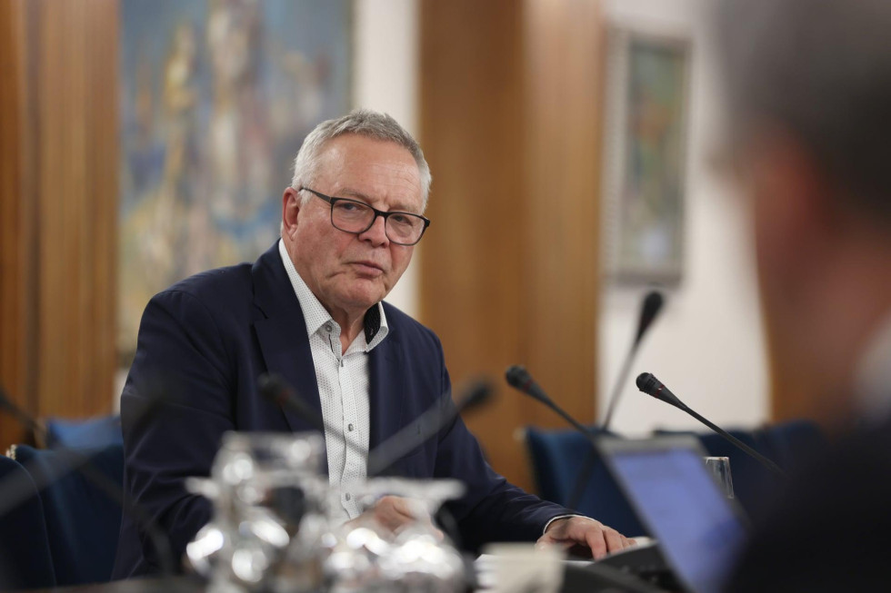 Minister Jože Novak sedi za mizo pred mikrofoni 