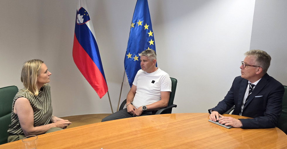 Ministrica (na levi strani), župan (na sredini) in državni sekretar (na desni strani) sedijo za mizo