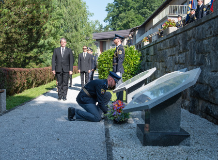 Policist polaga venec pred spominsko obeležje