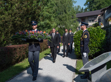 Minister za notranje zadeve Boštjan Poklukar z delegacijo hodi za policistom, ki nosi venec.