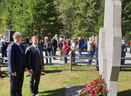Minister Poklukar in župan Občine Gorje Peter Torkar stojita pred spomenikom in se poklonita žrtvam