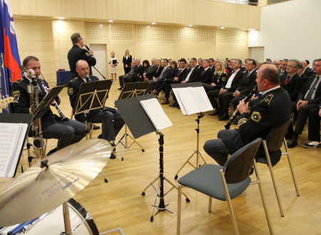 Člani Policijskega orkestra med igranjem v ospredju, v ozadju sedijo udeleženci dogodka