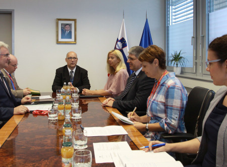 Slovenska delegacija sedi za mizo.